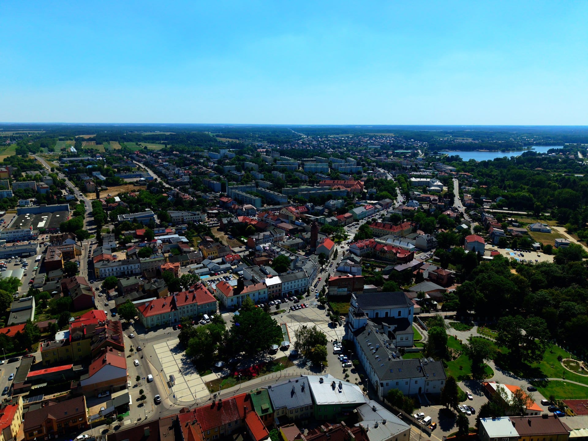 Panorama miasta z powietrza — zabudowa, zieleń i jezioro, ujęcie z drona