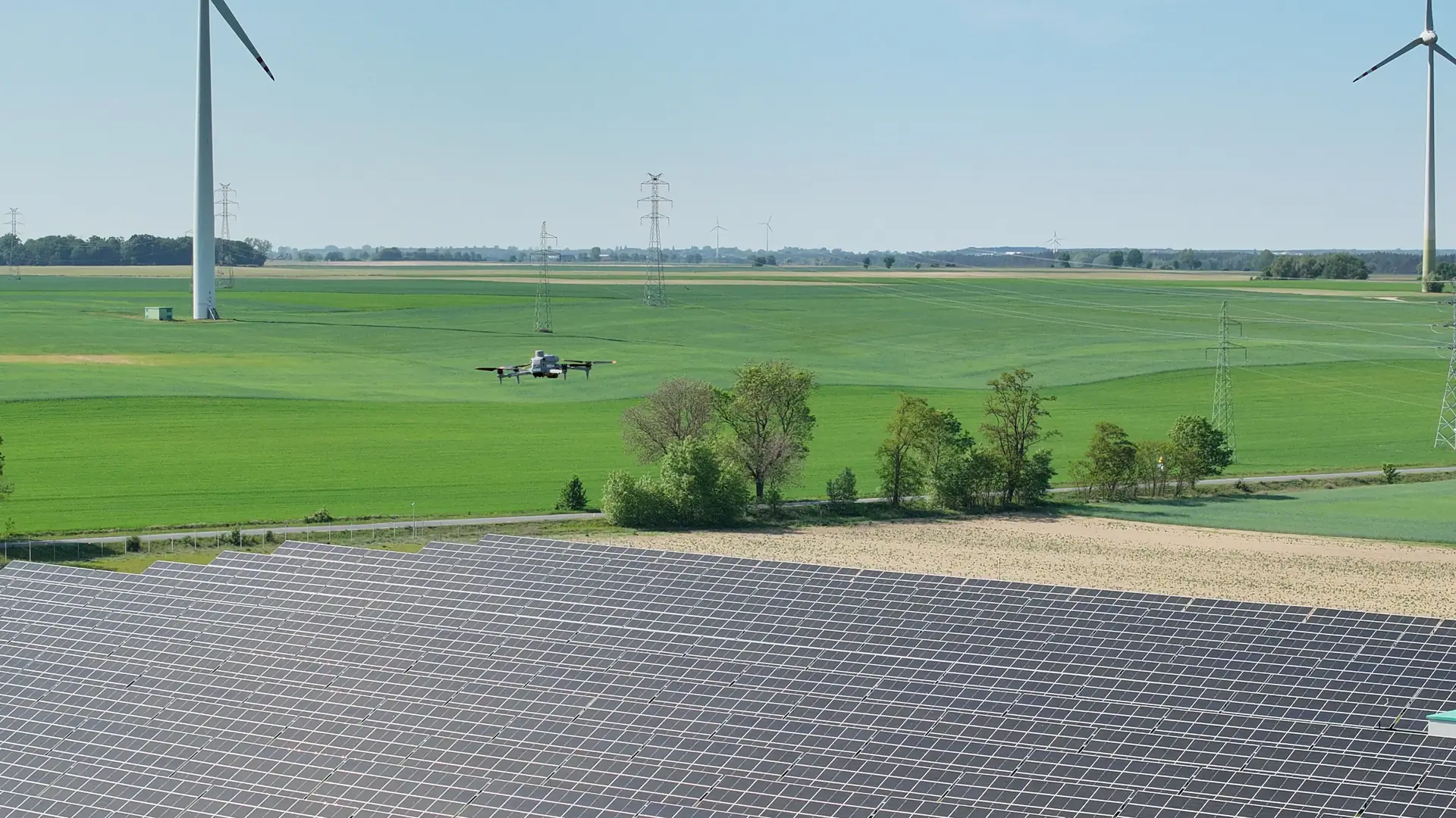 Dron w powietrzu nad farmą fotowoltaiczną podczas nalotu termowizyjnego